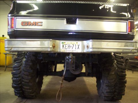 1984 GMC Sierra 3500 - Rear view of a black GMC pickup truck with oversized tires and a chrome bumper.