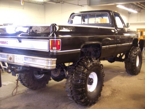 1984 GMC Sierra 3500 - This lifted 1984 GMC Sierra 3500 pickup truck is shown from the rear 3/4 angle.