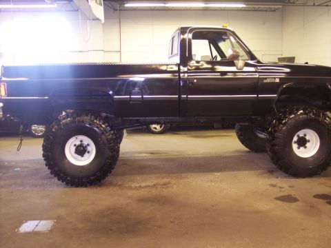 1984 GMC Sierra 3500 - Side view of a lifted 1984 GMC Sierra 3500 pickup truck with large tires.