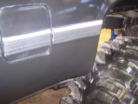 1984 GMC Sierra 3500 - Close-up of the side of a 1984 GMC Sierra 3500, showing the door trim and a large tire.