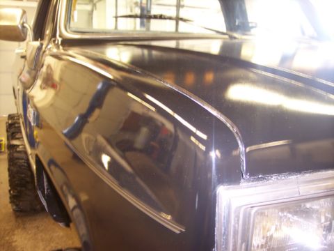 1984 GMC Sierra 3500 - Front view of a black 1984 GMC Sierra 3500 pickup truck, showing the fender and headlight detail.