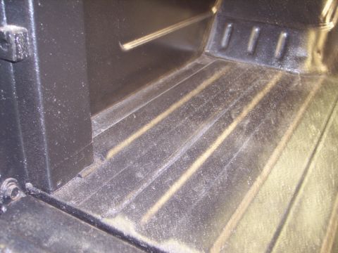 1984 GMC Sierra 3500 - The ribbed metal floor of a truck bed is visible, with a black panel on the left side. Text from Supermotors.net is in the lower right corn…