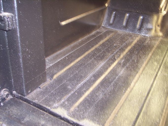 Black drop-in pickup bedliner with ribbed floor and bulkhead, dusty surface