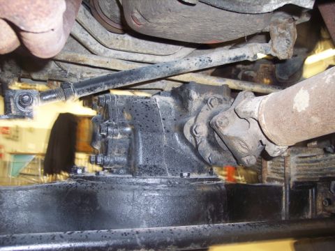 1984 GMC Sierra 3500 - Close-up of vehicle drivetrain parts, showing a transfer case and driveshaft connection.