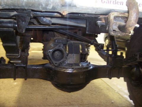 1984 GMC Sierra 3500 - Close-up of the rear axle and suspension system of a heavy-duty vehicle, showing leaf springs and the differential housing.