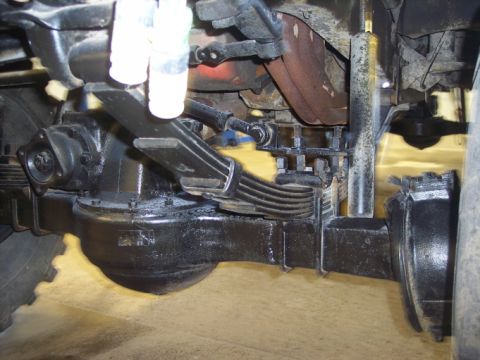 1984 GMC Sierra 3500 - Close-up view of the undercarriage of a heavy-duty truck, focusing on the rear axle and suspension system.