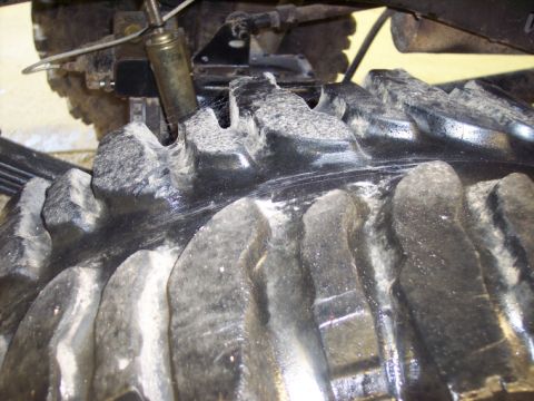 1984 GMC Sierra 3500 - A detailed view of a heavy-duty tire and its surrounding suspension, likely from a truck or off-road vehicle.