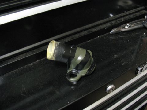 1997 Ford Crown Victoria - Automotive coolant elbow part with a distinctive black and green striped pattern.