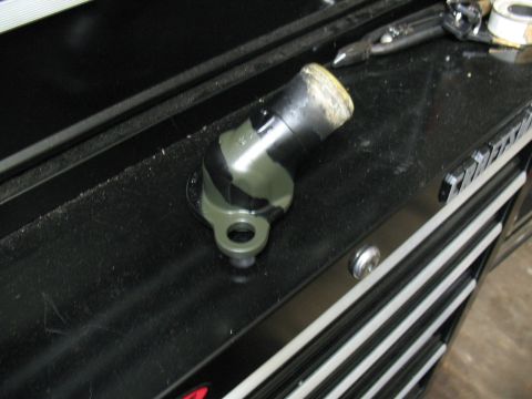 1997 Ford Crown Victoria - A coolant elbow part sits on a black toolbox with tools in the background.