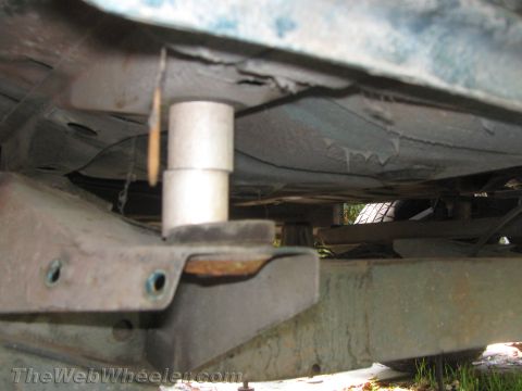 1987 Suzuki Samurai - Close-up view of a vehicle's undercarriage, showing suspension components and a lift block.
