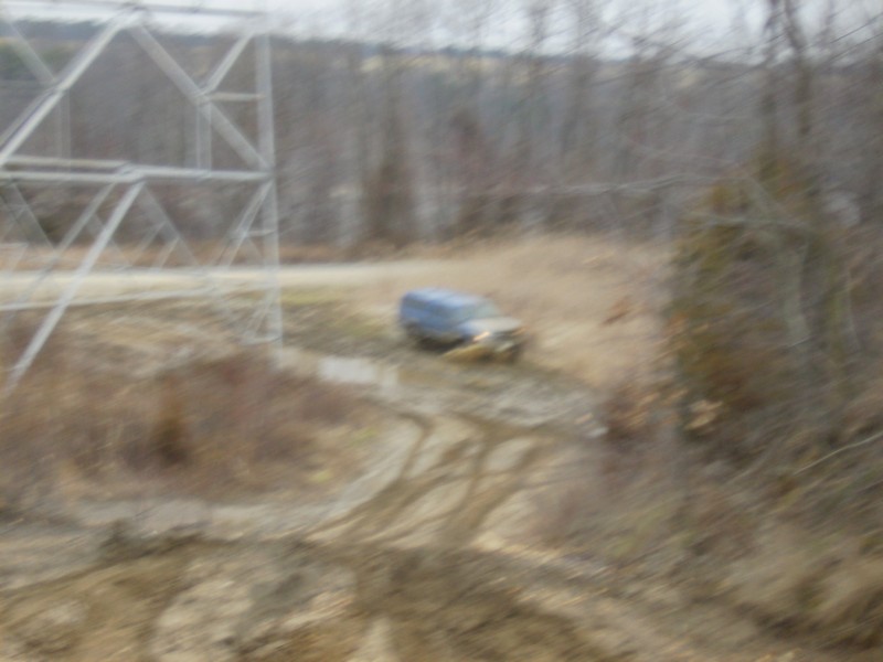 Blue SUV stuck in mud near power lines