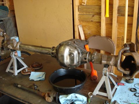 1995 Ford Bronco - A vehicle axle assembly is shown on jack stands, with a drain pan for fluids nearby.
