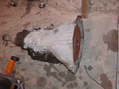 1991 Ford Bronco - An automatic transmission is shown resting on a concrete floor, likely in a garage or workshop setting.