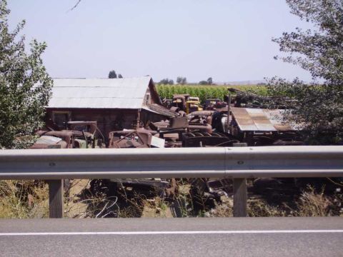 1969 Lincoln Continental - A collection of old vehicle parts and structures are piled up in a junkyard setting.