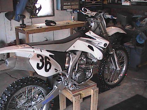 2007 Yamaha YZ450F - A white dirt bike with the number 36 prominently displayed on its side panel is shown in a workshop setting.