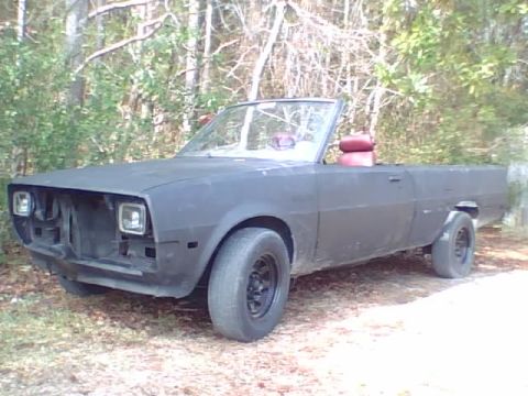 1981 Dodge Power Ram - This custom vehicle appears to be a modified pickup truck with a convertible top and a matte black finish.