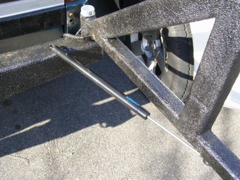 1993 Ford Bronco - A close-up view of the textured rear bumper support structure and a portion of the vehicle's tire.
