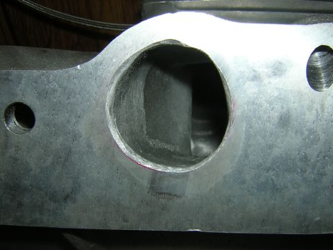 1979 Ford Bronco - Close-up view of a machined cylinder head intake port, showing internal structure and surface texture.