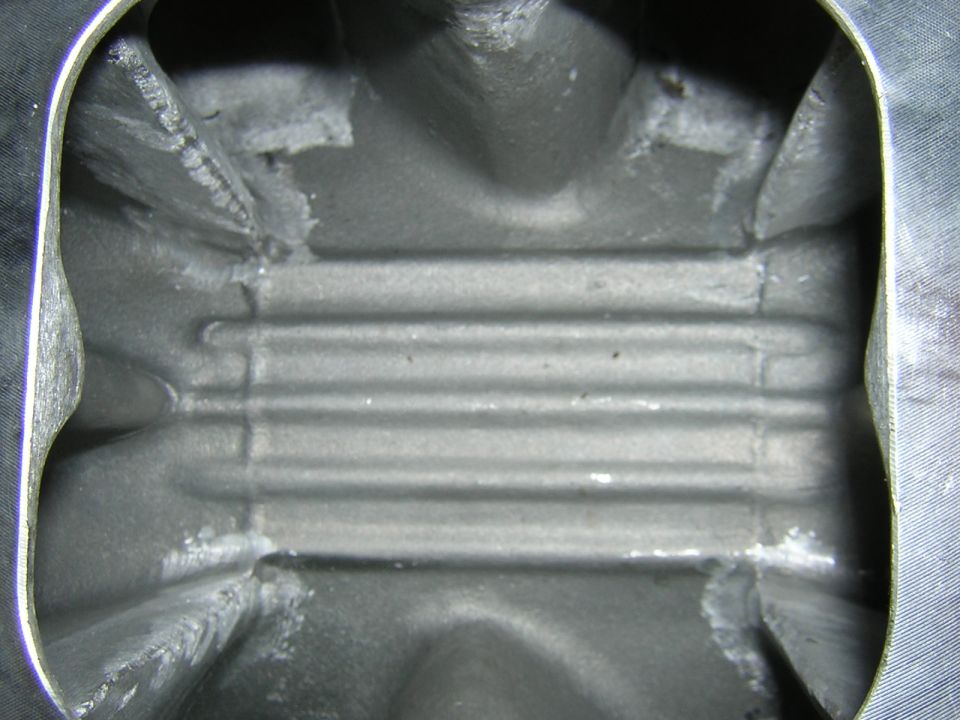 Close-up of the inside of an engine intake manifold with horizontal ridges