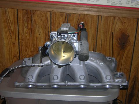 1979 Ford Bronco - Close-up view of an aftermarket intake manifold and throttle body assembly.