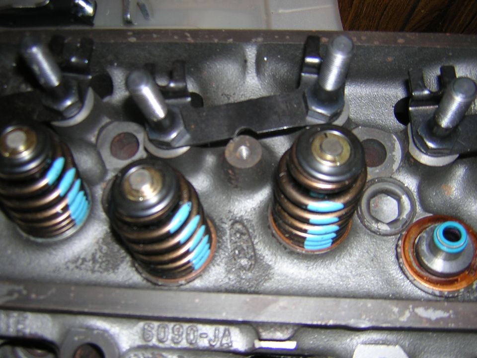 Cylinder head valve springs with blue dampers and a blue valve stem seal during assembly