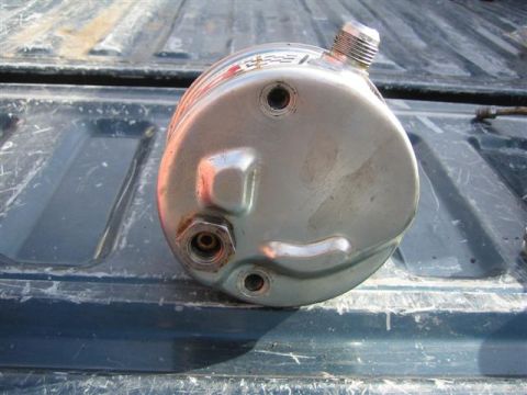 1994 Ford Bronco - A chrome power steering pump is shown, with visible text and threaded fittings, resting on a truck bed.