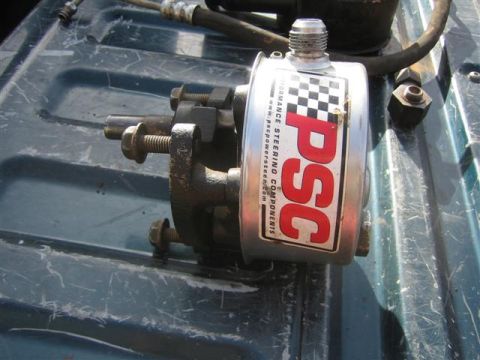 1994 Ford Bronco - PSC power steering component with checkered flag sticker is shown on a dark surface.
