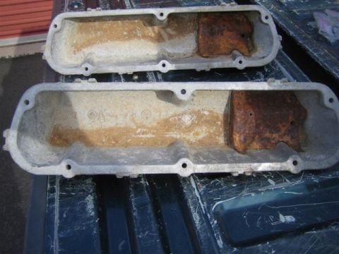 1994 Ford Bronco - A pair of aluminum valve covers, showing signs of wear and rust, are displayed on a dark surface.