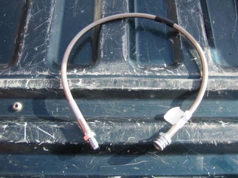 1994 Ford Bronco - A single brake hose is shown against a dark, textured background, with visible text at the bottom right.
