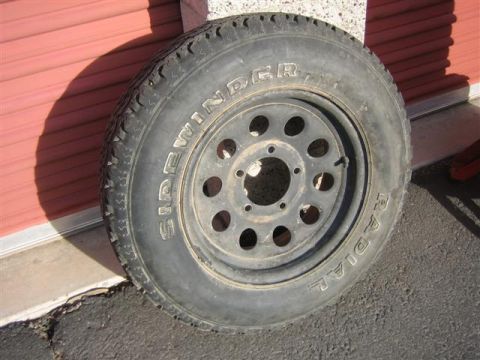 1994 Ford Bronco - A tire and wheel assembly is shown, with visible text including 'SIDEWINDER' and 'RADIAL'.