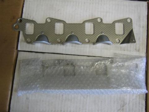 1994 Ford Bronco - Exhaust manifold gaskets shown, one is laid out and the other is wrapped in bubble wrap.
