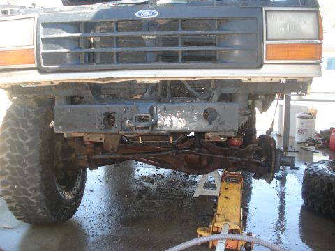 1989 Ford Bronco II - Front end of a 1989 Ford Bronco II being worked on, with the grille and bumper removed.