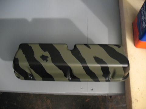 1985 Ford Crown Victoria LTD - A camaro valve cover painted with a tiger stripe camouflage pattern sits on a surface.