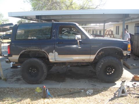 1989 Ford Bronco II - This modified Ford Bronco II is parked outside under a carport, showing off its lifted suspension and off-road tires.