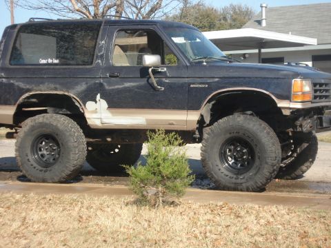 1989 Ford Bronco II - This modified 1989 Ford Bronco II sits high on large off-road tires, showing signs of wear and recent bodywork.