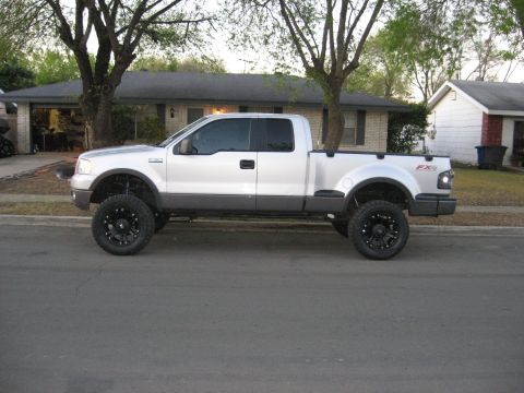 1979 Ford Bronco - This lifted Ford F-150 pickup truck is parked on a suburban street in front of a house.