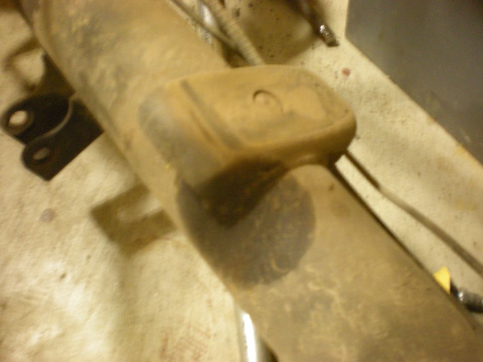 Close-up of a dirty suspension part with Supermotors.net logo