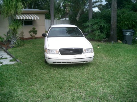 1999 Ford Crown Victoria - A white 1998 Ford Crown Victoria is parked on a grassy lawn in front of a house.