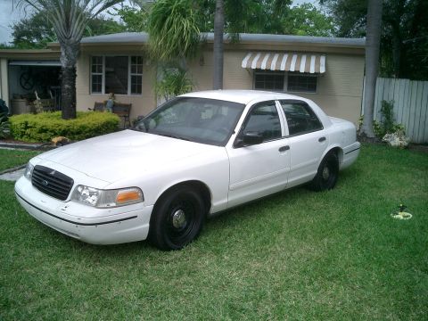 1999 Ford Crown Victoria - White Ford Crown Victoria sedan parked on grass in front of a house with a palm tree.