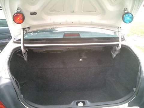 1999 Ford Crown Victoria - The trunk of a 1999 Ford Crown Victoria, equipped with red and blue emergency lights, is shown.