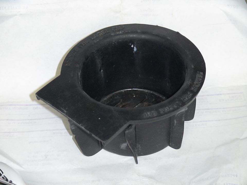 Black plastic cup holder with text reading "REMOVE FOR LARGE CUP"