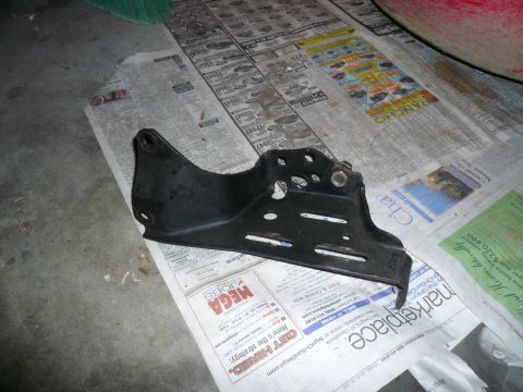 1975 Ford Ranchero - A metal bracket is placed on top of various newspaper pages.