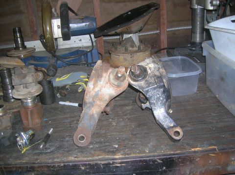 1985 Ford Bronco - Automotive suspension parts and tools are laid out on a workbench.