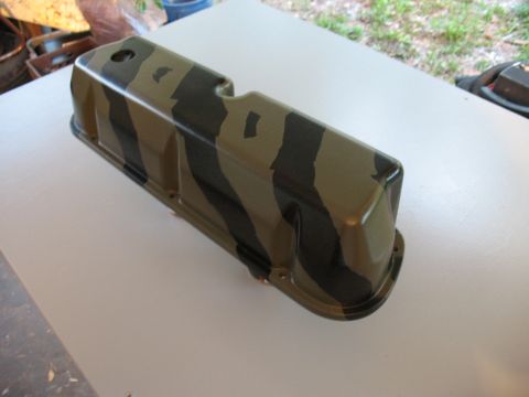 1985 Ford Crown Victoria LTD - A camouflage painted valve cover is shown resting on a flat surface.