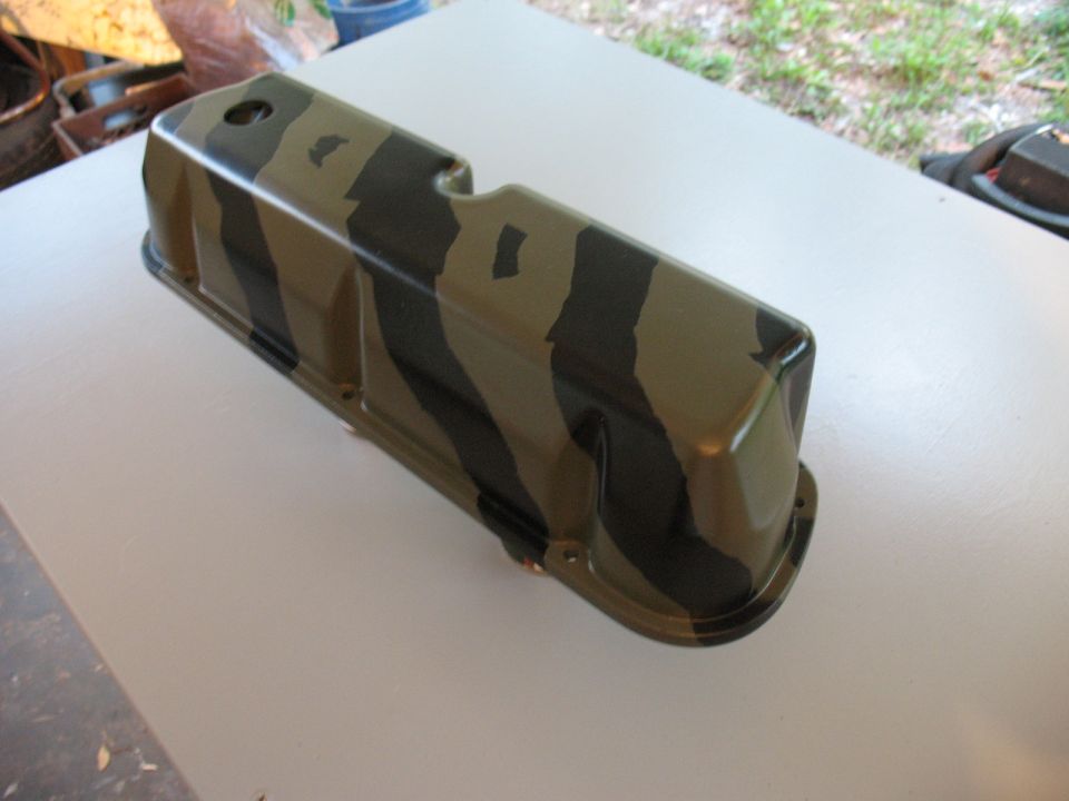 Camouflage painted valve cover sitting on a table