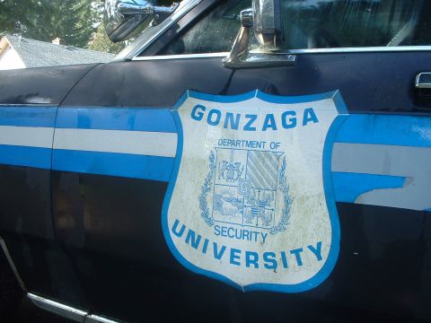 1987 Ford Crown Victoria LTD - A dark blue car displays a Gonzaga University Department of Security shield on its side, with blue and white stripes above.