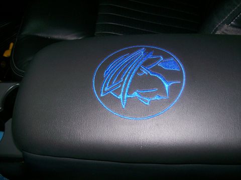 2003 Mercury Marauder - Close-up of the Mercury Marauder emblem embroidered on the vehicle's center console lid.