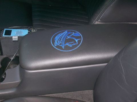 2003 Mercury Marauder - Interior view of a vehicle's center console armrest a blue embroidered emblem.