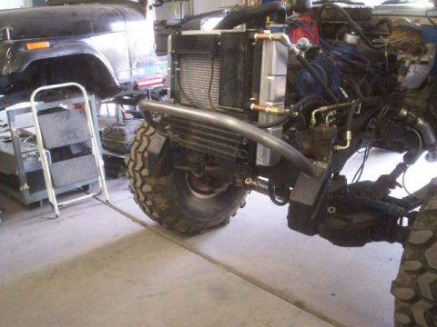 1982 Toyota 4Runner - Close-up of an off-road vehicle's engine and suspension system, with another vehicle in the background.