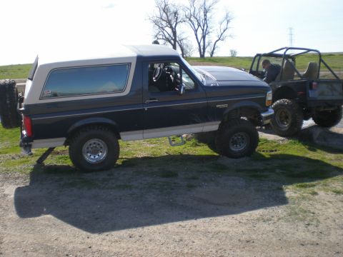 1993 Ford Bronco - A 1993 Ford Bronco and a Jeep are parked off-road on a sunny day.